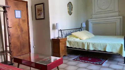 a bedroom with a bed and a table in a room at Belle de Nuit in Oppède