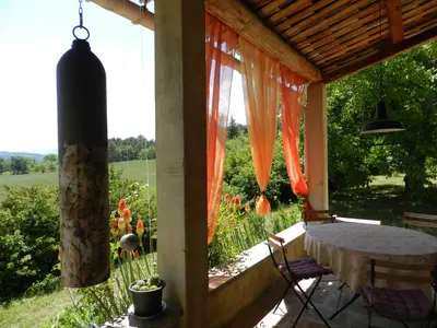 a porch with a table and a view of a field at Maison d'artiste in Gargas