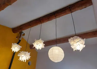 three chandeliers with paper lanterns hanging from a ceiling at Maison d'artiste in Gargas