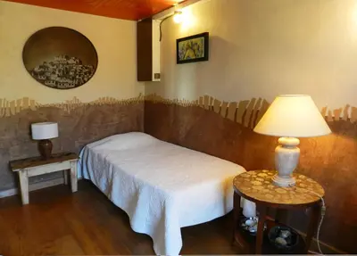a bedroom with a bed and a lamp on a table at Maison d'artiste in Gargas