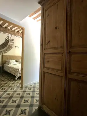 a room with a wooden cabinet and a bedroom at Le Mas du Félibre in Caumont-sur-Durance