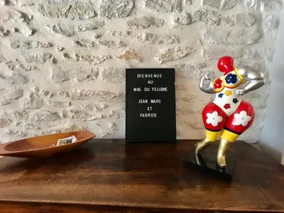 a figurine on a table next to a sign at Le Mas du Félibre in Caumont-sur-Durance