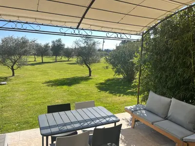 a patio with a couch and a table and chairs at Gîtes dans Mas en pierres in Robion en Luberon