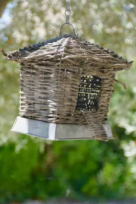 a bird feeder hanging from a chain with a birdhouse at Villa Louanne in Pertuis
