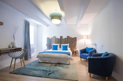 a bedroom with a bed and a blue chair at La Bastide des Bourguets Adults Only, Mont Ventoux in Sault-de-Vaucluse