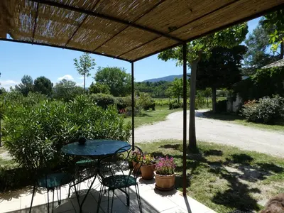 a patio with a table and chairs and a view at Les Biguières in Maubec