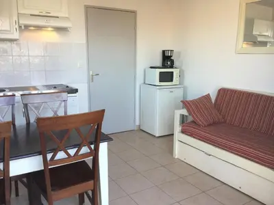 a kitchen with a couch and a table and a microwave at Charming rental with shared-pool in the Alpilles. in Mouriès