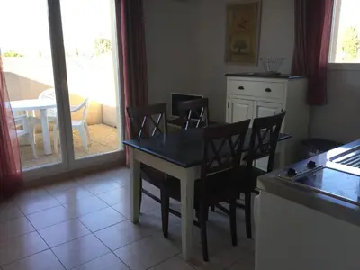 a kitchen with a table and chairs and a table at Charming rental with shared-pool in the Alpilles. in Mouriès