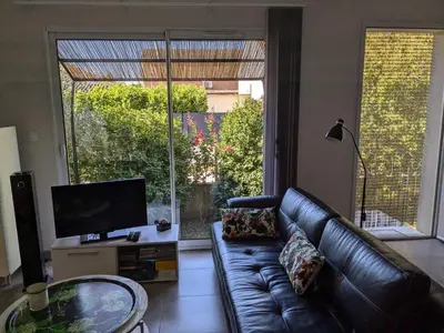 a kitchen with a table and chairs and a fan at La Maison sous l'olivier in Morières-lès-Avignon