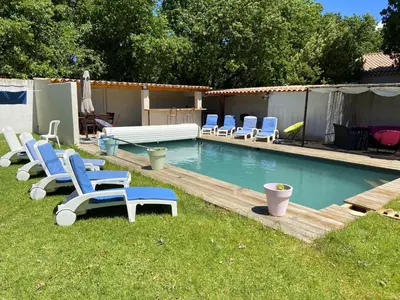 a swimming pool with blue chairs and a pool at Nice house with private-pool situated in the heart of the Luberon in Maubec