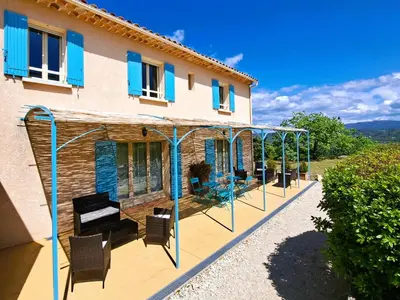 a house with a patio with blue shutters on it at Cante Grillet - 295 Chemin des Contards - 84480 Lacoste in Lacoste