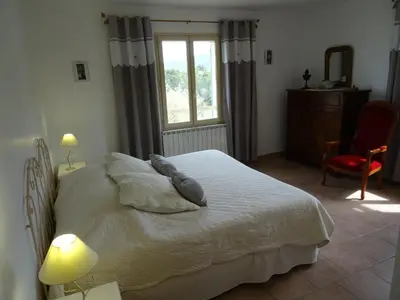 a bedroom with a bed with pillows and a window at Cante Grillet - 295 Chemin des Contards - 84480 Lacoste in Lacoste