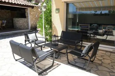 a group of chairs and tables on a patio at Very pleasant vacation rental with heated pool in the Luberon in Gargas