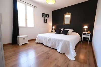 a bedroom with a white bed and a black wall at Very pleasant vacation rental with heated pool in the Luberon in Gargas