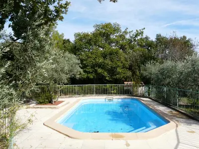 a swimming pool in a yard with a fence at Spacious villa on two levels in Cabrières-dʼAvignon