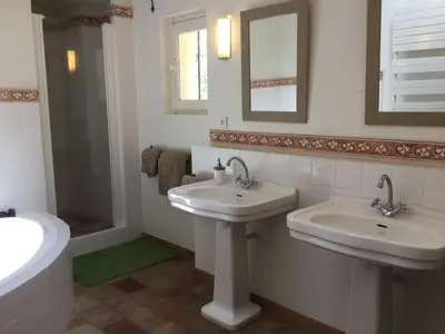 a white bathroom with two sinks and a mirror at 19th century Provencal Mas with pool in Provence in the Luberon, sleeps 6 in Lacoste