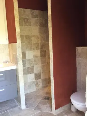 a bathroom with a toilet and a tiled wall at 19th century Provencal Mas with pool in Provence in the Luberon, sleeps 6 in Lacoste