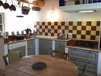 a kitchen with a wooden table and a table and a table at 19th century Provencal Mas with pool in Provence in the Luberon, sleeps 6 in Lacoste