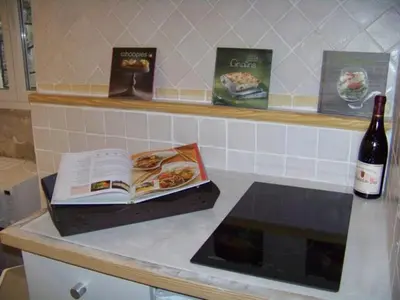 a book sitting on a counter with a bottle of wine at Le petit trésor du Luberon in Ménerbes