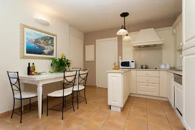 a kitchen with a table and chairs in a room at Madame Vacances Domaine du Provence Country Club Service Premium in Saumane-de-Vaucluse