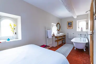 a bedroom with a bed and a tub and a sink at Belle De Jour -A Provencal gem Private heated pool in Gordes