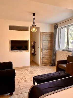 a living room with a flat screen tv and a couch at Le Mas des Mirabelles in Cabannes