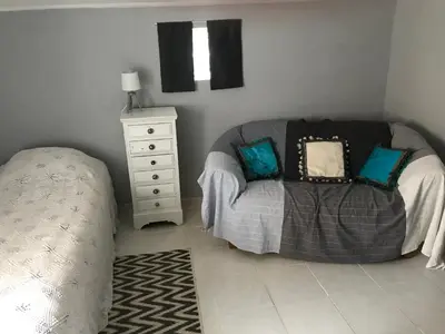 a bedroom with a bed and a dresser with a pillow at Chambre d'hôtes Le Cèdre in Apt