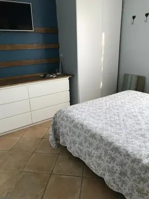a bedroom with a bed and a dresser and a television at L'Atelier des Coudelières in Le Thor