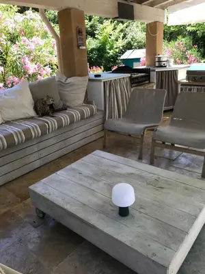 a cat laying on a couch on a patio at L'Atelier des Coudelières in Le Thor