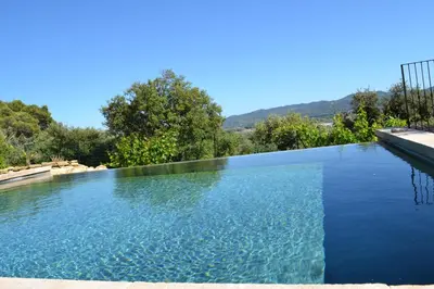 a large swimming pool with blue water at La cubaine in Puget