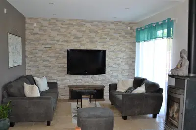 a living room with two couches and a tv on a brick wall at La cubaine in Puget