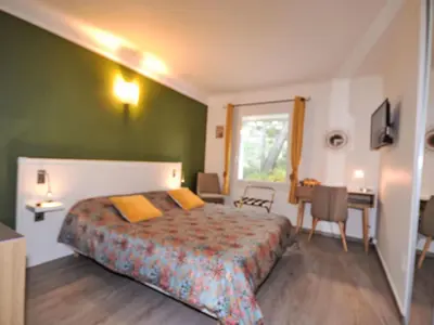 a bedroom with a bed and a table and a window at Holiday Home Luberon Vidauque by Interhome in Cavaillon