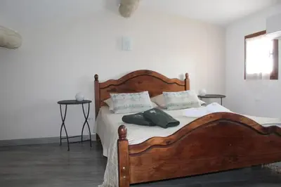a bedroom with a large wooden bed with two pillows at Maison de charme à Mérindol + Jardin in Mérindol