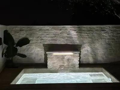 a stone fireplace with a fountain in front of it at Maison de charme à Mérindol + Jardin in Mérindol