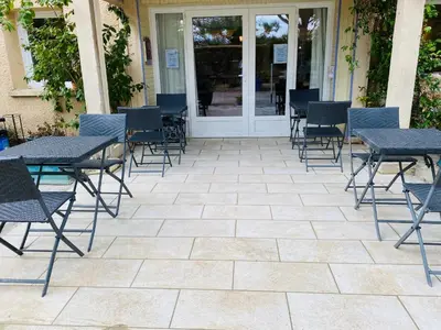 a table with chairs and a blue umbrella at Hotel Carina in Apt