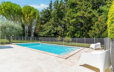 a swimming pool in a yard next to a fence at Cozy Home In Pernes Les Fontaines in Pernes-les-Fontaines