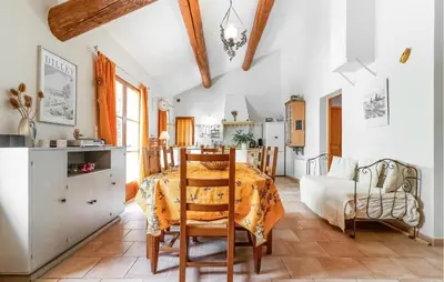 a kitchen and living room with a table and chairs at Cozy Home In Pernes Les Fontaines in Pernes-les-Fontaines