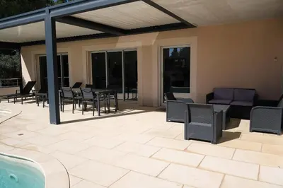 a patio with chairs and a couch and a table at very pretty contemporary villa with pool located in Aureille in the alpilles, close to the center on foot. sleeps 4. in Aureille