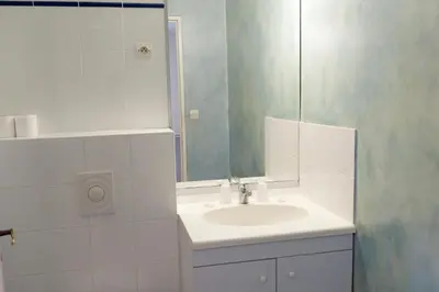 a white bathroom with a sink and a mirror at VTF Les Florans in Bédoin