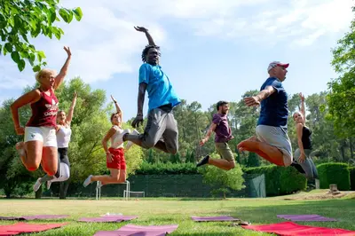 a group of people jumping in the air in a park at VTF Les Florans in Bédoin