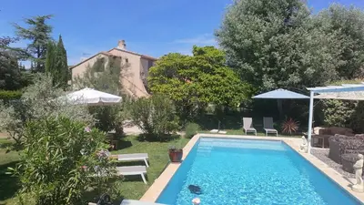 a swimming pool in the yard of a house at La belle histoire gîte Luberon in Bédoin
