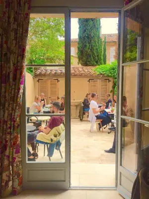 a group of people sitting at tables outside a window at Maison Du Collectionneur in Aix-en-Provence