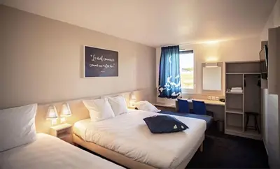 a hotel room with two beds and a window at Ace Hôtel Salon de Provence in Salon-de-Provence