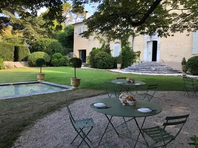 two tables and chairs in front of a house at Bastide de Ganay - Saint Jérôme in Aix-en-Provence