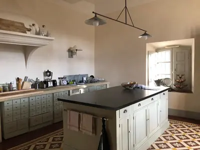 a large kitchen with a black counter top in it at Bastide de Ganay - Saint Jérôme in Aix-en-Provence