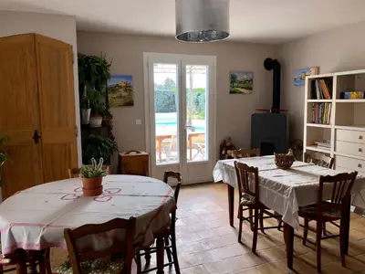 a living room with two tables and chairs and a room at Le clos des vergers in LʼIsle-sur-la-Sorgue