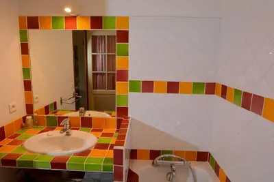 a colorful bathroom with two sinks and a mirror at La Tuilière en Luberon in Cadenet