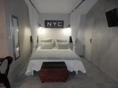 a bedroom with a large bed and a sign on the wall at Gite Le city en Provence in Lambesc