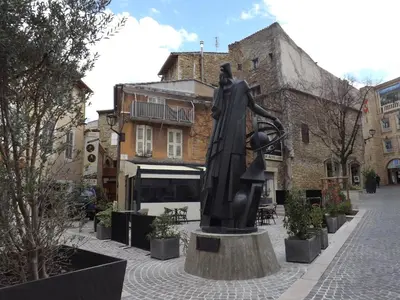 a statue of a woman standing in a street at le COIN salonais in Salon-de-Provence