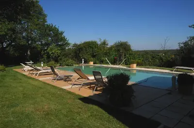 a swimming pool with lounge chairs next to a field at un lit en provence in Éguilles